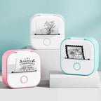 Three compact mini thermal printers in pink, white, and blue with printed images and text.